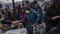Warga menerima pembagian makanan di dapur umum di luar stasiun kereta Lviv, Ukraina barat, Kamis (3/3/2022). Serangan Rusia menjadikan akhir musim dingin di Ukraina tidak terasa dingin lagi.