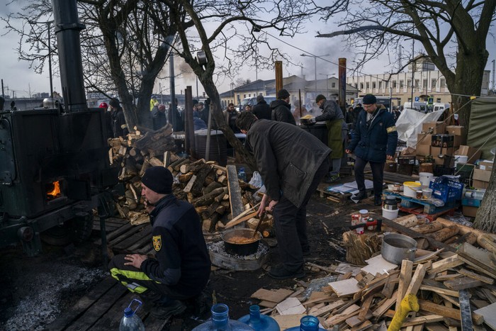 Relawan mendirikan dapur umum di luar stasiun kereta Lviv, Ukraina. Makanan dibuat untuk para pengungsi akibat invasi Rusia.