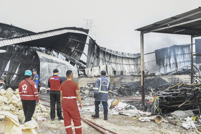 Sejumlah petugas pemadam kebakaran dan PMI mengamati bangunan yang rusak akibat kebakaran pabrik pengolahan limbah di Desa Cicau, Cikarang, Kabupaten Bekasi, Jawa Barat, Jumat (4/3/2022). Menurut keterangan warga kebakaran tersebut diduga akibat ledakan mesin pada pukul 13.00 WIB, sementara sebanyak delapan mobil pemadam kebakaran diturunkan untuk memadamkan api. ANTARA FOTO/Fakhri Hermansyah/wsj.