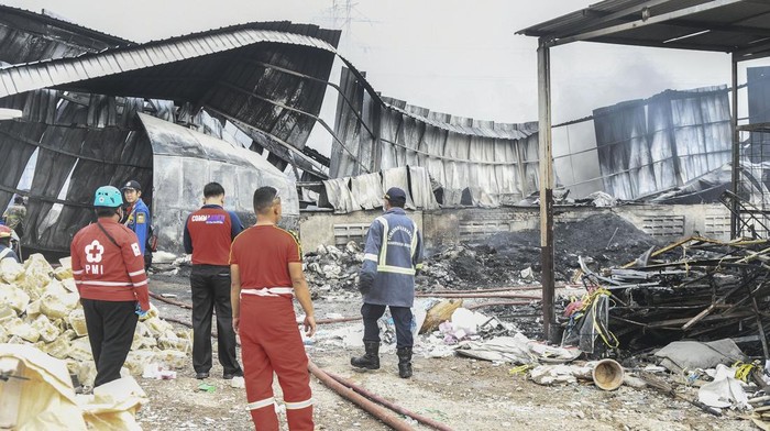 Sejumlah petugas pemadam kebakaran dan PMI mengamati bangunan yang rusak akibat kebakaran pabrik pengolahan limbah di Desa Cicau, Cikarang, Kabupaten Bekasi, Jawa Barat, Jumat (4/3/2022). Menurut keterangan warga kebakaran tersebut diduga akibat ledakan mesin pada pukul 13.00 WIB, sementara sebanyak delapan mobil pemadam kebakaran diturunkan untuk memadamkan api. ANTARA FOTO/Fakhri Hermansyah/wsj.