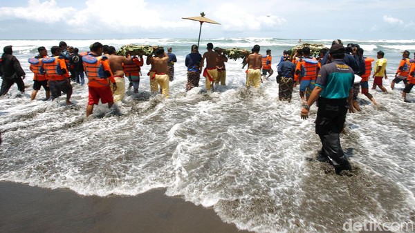 Abdi dalem melarung sesaji dan ubo rampe pada prosesi labuhan alit di Pantai Parangkusumo.