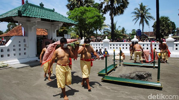 Abdi dalem Kraton Yogyakarta berurutan menggotong ube rampe yang akan dilarung ke Pantai Parangkusumo, Bantul. 