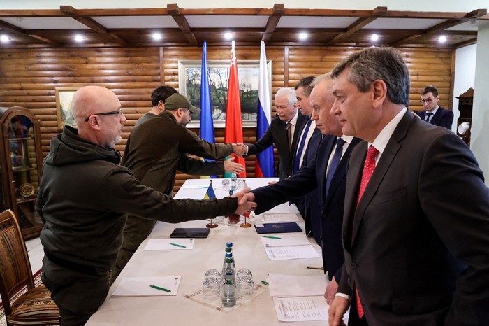 Menteri Pertahanan Ukraina Oleksii Reznikov (kiri) berjabat tangan dengan negosiator Rusia sebelum pembicaraan antara delegasi dari Ukraina dan Rusia di wilayah Brest Belarus, Kamis (3/3/2022), setelah invasi Rusia ke Ukraina. Rusia dan Ukraina akan membahas gencatan senjata pada pembicaraan mendatang di perbatasan antara Polandia dan Belarusia, kata kepala negosiator Moskow, Rabu (2/3), hampir satu minggu setelah invasi Rusia ke tetangganya yang pro-Barat. (Foto oleh Maxim GUCHEK / BELTA / AFP) / Belarus OUT)