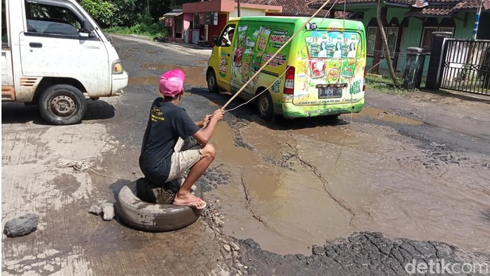 Warga Cianjur mancing di tengah jalan sebagai aksi protes rusaknya jalan Provinsi menuju Cianjur selatan.