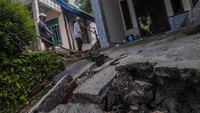Warga melihat kondisi rumah yang rusak akibat pergerakan tanah di Desa Curug Panjang, Lebak, Banten, Jumat (4/3/2022).