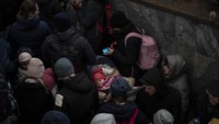 Tampak dalam gambar seorang bayi yang dibopong ibunya. Mereka adalah para penumpang yang menunggu kereta ke Polandia, di dalam stasiun kereta api Lviv, Minggu, 27 Februari 2022, di Lviv, Ukraina barat. Foto: AP/Bernat Armangue
