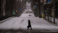 Salah satu Kota Besar di Ukraina yang menjadi sasaran gempuran Rusia terlihat kosong melompong dan menerapkan jam malam. Orang-orang berjalan di sepanjang jalan yang kosong saat jam malam, di Kyiv, Ukraina, Selasa, 1 Maret 2022. Foto: AP/Emilio Morenatti