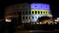 Selanjutnya, Roma. Bangunan paling bersejarah Colosseum pun ikut merefleksikan cahaya lampu sorot dengan warna Bendera Ukraina. REUTERS/Guglielmo Mangiapane.