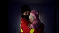 Seorang ibu menggendong dan memeluk bayinya yang lucu di tengah peperangan Rusia dan Ukraina. Foto: AP/Andreea Alexandru