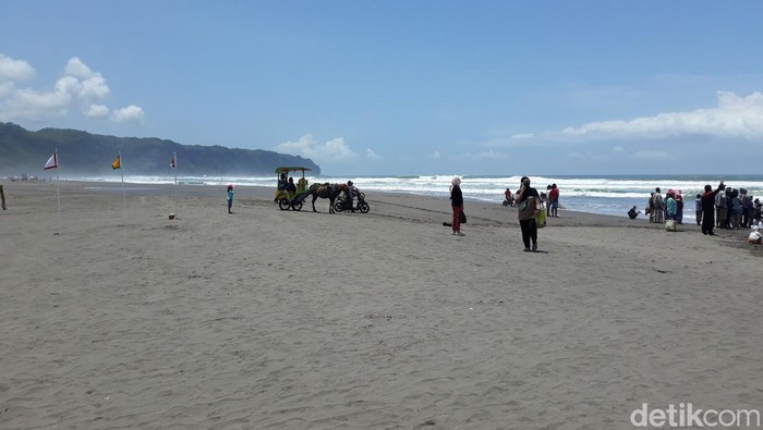 Petugas menegur wisatawan di Pantai Parangtritis yang tidak mengenakan masker, Minggu (6/3/2022).