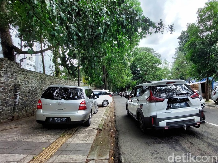 Parkir liar mobil pengunjung Kebun BInatang Bandung di trotoar Jalan Tamansari.