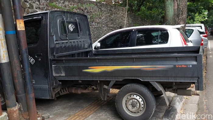Parkir liar mobil pengunjung Kebun BInatang Bandung di trotoar Jalan Tamansari.