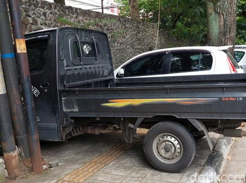 Parkir liar mobil pengunjung Kebun BInatang Bandung di trotoar Jalan Tamansari.