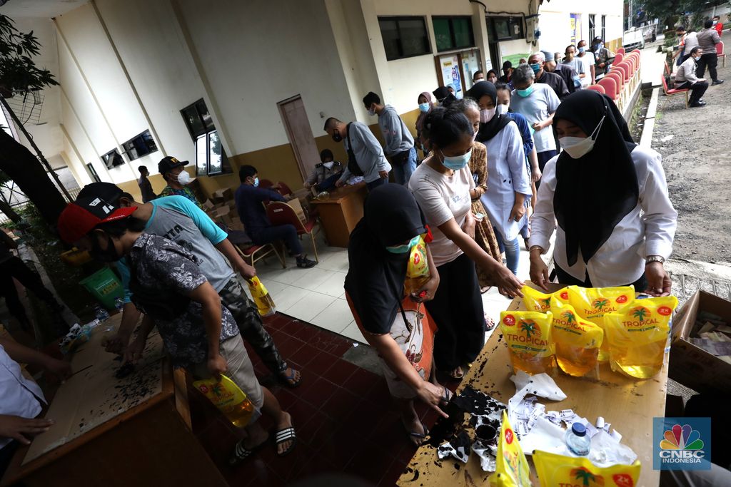 Warga antre untuk mendapatkan minyak goreng kemasan di GOR BRI, Radio Dalam, Jakarta, Senin (7/2/2022). Polsek Kebayoran Baru menggelar oprasi pasar minyak goreng murah mulai tanggal 7-9 Maret 2022. (CNBC Indonesia/ Tri Susilo)