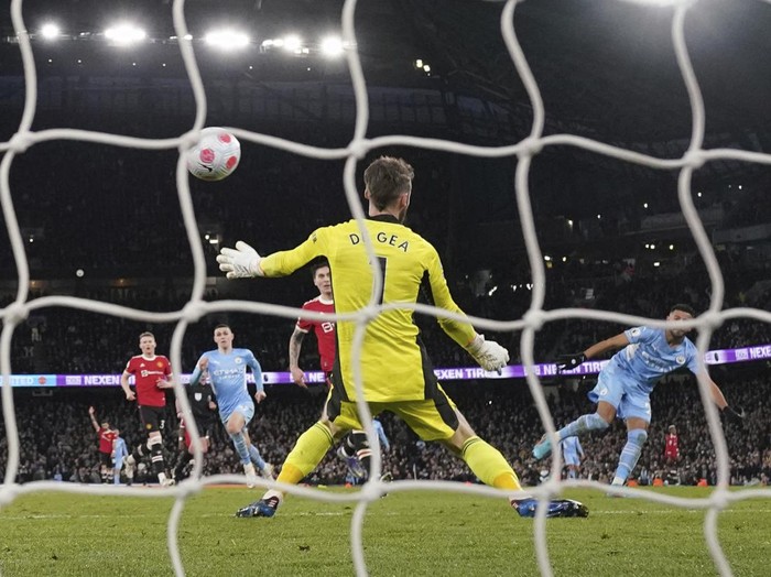 Manchester City's Riyad Mahrez, right, scores his side's fourth goal during the English Premier League soccer match between Manchester City and Manchester United, at the Etihad stadium in Manchester, England, Sunday, March 6, 2022. (AP Photo/Jon Super)