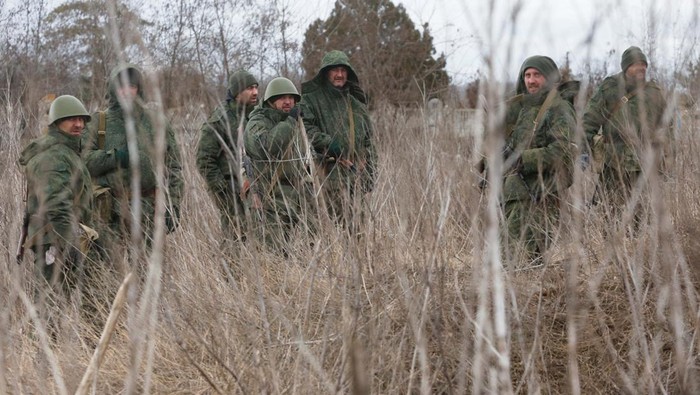 Dikuasai Separatis Pro-Rusia, Tank Baja Hilir Mudik di Donetsk Service members of pro-Russian troops in uniforms without insignia are seen in the separatist-controlled village of Bugas during Ukraine-Russia conflict in the Donetsk region, Ukraine March 6, 2022. REUTERS/Alexander Ermochenko