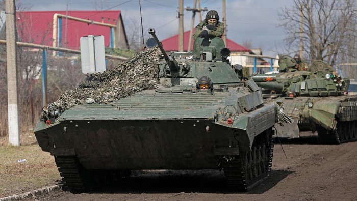 Dikuasai Separatis Pro-Rusia, Tank Baja Hilir Mudik di Donetsk Service members of pro-Russian troops in uniforms without insignia are seen in the separatist-controlled village of Bugas during Ukraine-Russia conflict in the Donetsk region, Ukraine March 6, 2022. REUTERS/Alexander Ermochenko