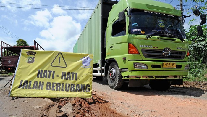 JALAN LINTAS SUMATERA DI MUAROJAMBI RUSAK Sejumlah kendaraan melaju pelan saat melintasi Jalan Lintas Sumatera yang rusak di Mestong, Muarojambi, Jambi, Senin (7/3/2022). Jalan nasional penghubung Jambi dengan Sumatera Selatan tersebut rusak di sejumlah titik sehingga membahayakan keselamatan pengendara. ANTARA FOTO/Wahdi Septiawan/rwa.