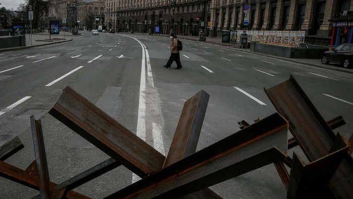A police guards as anti-tank constructions are seen in central Kyiv, Ukraine March 7, 2022. REUTERS/Gleb Garanich