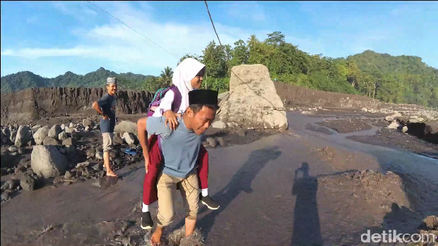 siswa digendong orang tua lewati lahar dingin