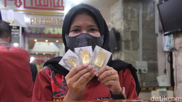 Staf Toko Emas Bulan Purnama menunjukkan emas Antam batangan yang dijual