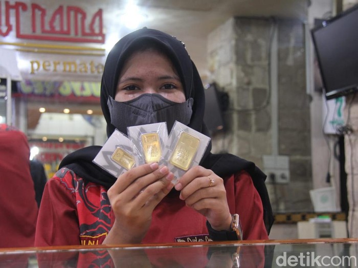 Staf Toko Emas Bulan Purnama menunjukkan emas Antam batangan yang dijual