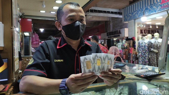 Staf Toko Emas Bulan Purnama menunjukkan emas Antam batangan yang dijual