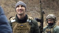 Klitschko mengenakan pakaian militer agar terlindungi dari peluru Rusia. Terlihat di belakangnya tentara lain menenteng senjata api. (Foto: Efrem Lukatsky/AP)
