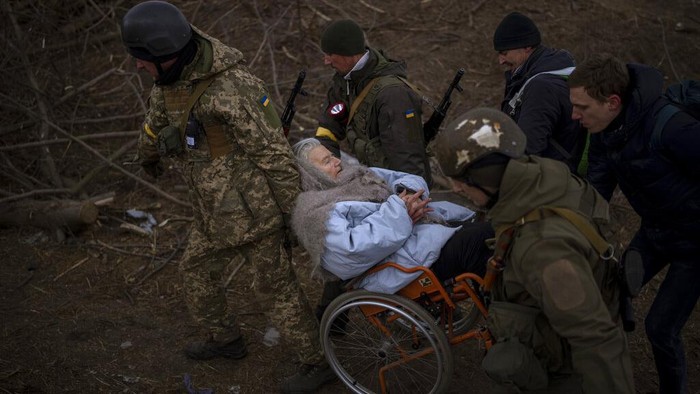 A firefighter holds the baby of a refugee fleeing the conflict from neighboring Ukraine at the Romanian-Ukrainian border, in Siret, Romania, Monday, March 7, 2022. (AP Photo/Andreea Alexandru)