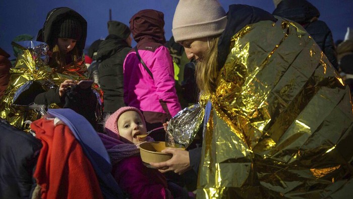 Cuaca Dingin Menambah Derita Korban Perang Ukraina A firefighter holds the baby of a refugee fleeing the conflict from neighboring Ukraine at the Romanian-Ukrainian border, in Siret, Romania, Monday, March 7, 2022. (AP Photo/Andreea Alexandru)