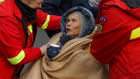 Departemen Situasi Gawat Darurat menolong Katia, nenek 90 tahun yang mengungsi, di perbatasan Ukraina dan Rumania, Sabtu (5/3/2022). (AP Photo/Andreea Alexandru)