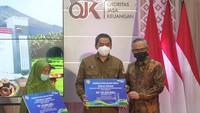 Pada kesempatan itu pula, Ketua Dewan Komisioner Otoritas Jasa Keuangan (OJK) Wimboh Santoso (kanan) memberikan santunan jaminan kecelakaan kerja kepada ahli waris saat peresmian Kantor OJK Purwokerto, di Banyumas, Jateng, Selasa (8/3/2022).
