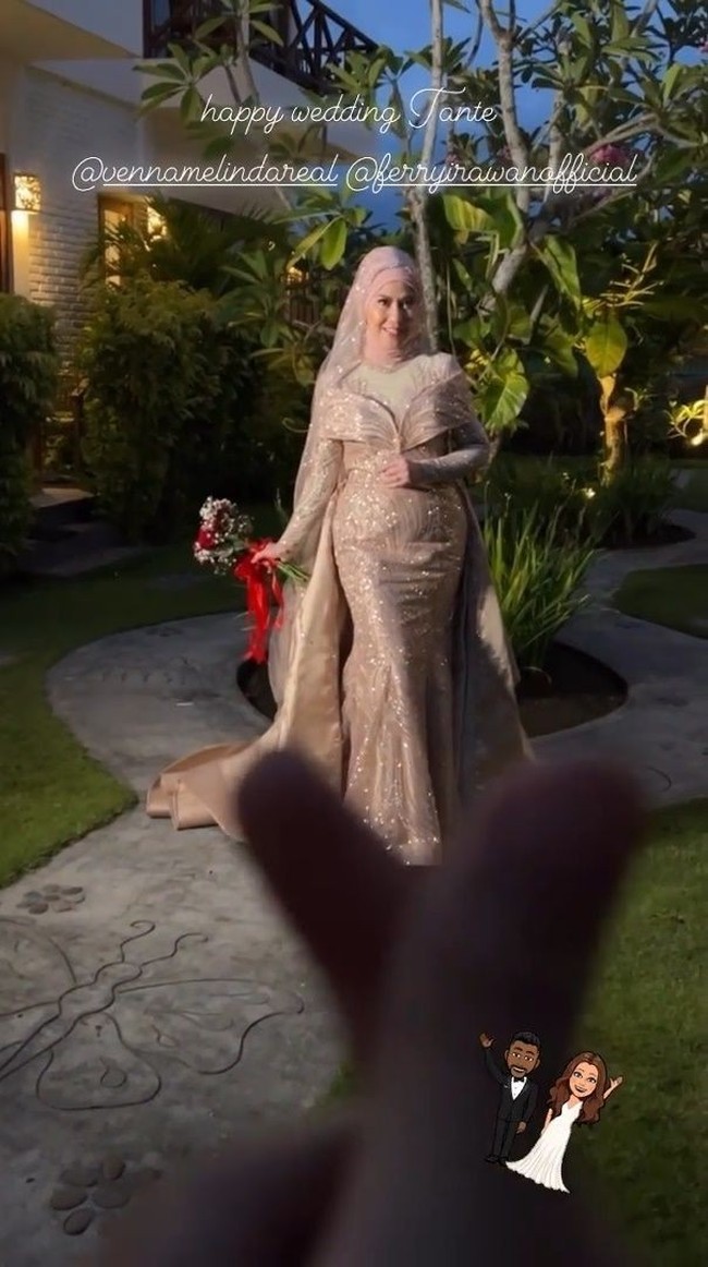 Dengan gaun bentuk duyung yang memperlihatkan lekuk tubuhnya, Venna Melinda tampil begitu menawan. Penampilannya itu dilengkapi dengan hijab berwarna senada dan sebuah hand bouquet berpita merah yang digenggamnya. Foto: Instagram