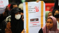 Massa aksi membawa poster pembawa pesan, dan seruan tuntutan. 