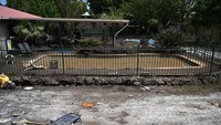 Tampak sebuah kolam renang warga yang kini penuh air banjir dan lumpur.  