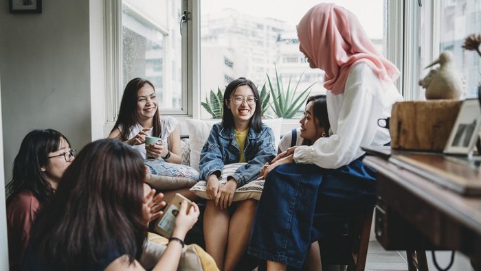 Friends talking and drinking coffee at home
