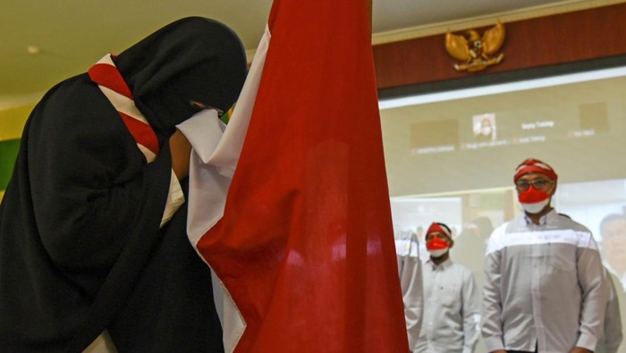 8 Napi Terorisme di Medan Ucap Ikrar Setia pada NKRI Seorang narapidana tindak pidana terorisme mencium bendera Merah Putih usai mengucap ikrar setia pada Negara Kesatuan Republik Indonesia (NKRI) di Lapas Kelas I Tanjung Gusta, Kota Medan, Sumatera Utara, Rabu (9/3/2022). Sebanyak delapan narapidana kasus terorisme di Lapas kota itu berikrar setia pada NKRI dan berjanji berpegang teguh pada Pancasila dan UUD 1945. ANTARA FOTO/Fransisco Carolio/WS/aww.