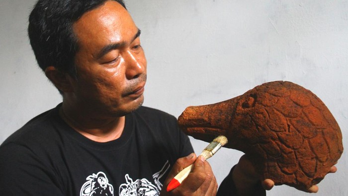 Arkeolog dari Balai Pelestarian Cagar Budaya (BPCB) Trowulan membersihkan artefak kuno berupa arca kepala angsa yang ditemukan saat ekskavasi tahap ketiga di candi Srigading, Lawang, Malang, Jawa Timur, Rabu (9/3/2022). Dari temuan puluhan artefak kuno berupa bokor berpenutup emas, teko tembaga, alat pertanian logam, arca dan periuk tembaga tersebut makin memperkuat dugaan bahwa situs Srigading adalah bangunan suci yang dibangun pada era kerajaan Mataram Kuno di abad 10 Masehi. ANTARA FOTO/Ari Bowo Sucipto/aww.