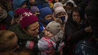 Di stasiun kereta api di Kyiv, kerumunan orang yang membawa barang bawaan berdiri dalam cuaca dingin saat mereka menunggu kesempatan untuk naik kereta. Di atas dan di bawah kereta ada pelukan yang penuh air mata. AP/Emilio Morenatti