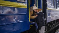 Stanislav, 40, mencium istrinya Anna, 35, di kereta ke Lviv saat mereka mengucapkan selamat tinggal di stasiun Kyiv, Ukraina. Stanislav tinggal untuk berperang sementara keluarganya meninggalkan negara itu untuk mencari perlindungan sebuah negara tetangga. AP/Emilio Morenatti