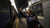 Natalia, 57, mengucapkan selamat tinggal kepada putri dan cucunya di kereta api ke Lviv di stasiun Kyiv, Ukraina. AP/Emilio Morenatti