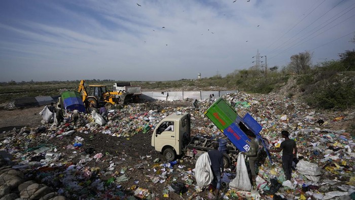 A man collects sand on horse backs and moves past the polluted banks of River Tawi in Jammu, India, Wednesday, March 9, 2022.(AP Photo/Channi Anand)