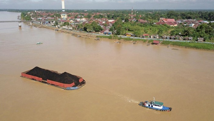 Foto udara kapal tongkang bermuatan batu bara melintasi aliran Sungai Batanghari di Jambi, Selasa (8/3/2022). Pemerintah Daerah setempat kembali mewacanakan pemaksimalan Sungai Batanghari sebagai alternatif pengangkutan batu bara guna mengurai kepadatan angkutan hasil tambang di jalur darat provinsi itu, tapi terkendala laju pendangkalan di sejumlah titik. ANTARA FOTO/Wahdi Septiawan/aww.