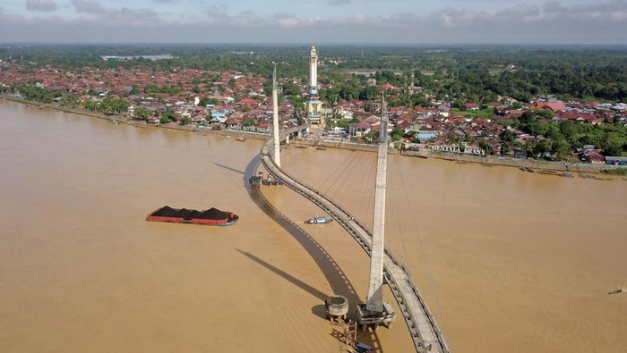 Foto udara kapal tongkang bermuatan batu bara melintasi aliran Sungai Batanghari di Jambi, Selasa (8/3/2022). Pemerintah Daerah setempat kembali mewacanakan pemaksimalan Sungai Batanghari sebagai alternatif pengangkutan batu bara guna mengurai kepadatan angkutan hasil tambang di jalur darat provinsi itu, tapi terkendala laju pendangkalan di sejumlah titik. ANTARA FOTO/Wahdi Septiawan/aww.