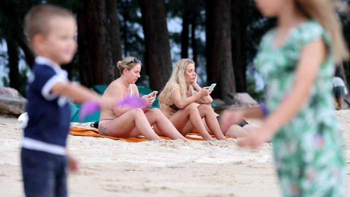Turis Rusia duduk di pantai di Phuket, Thailand pada 8 Maret 2022