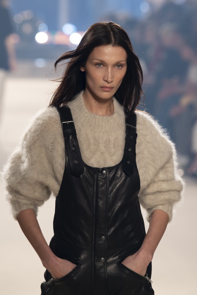 Tak melulu transparan, Bella Hadid juga memakai busana yang jauh dari kesan seksi di catwalk. Seperti kombinasi overall dan sweater rancangan Isabel Marant ini. (Foto: Getty Images/Kristy Sparow)