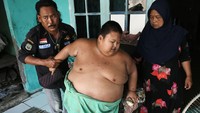 Rafka Adiputra dibantu kedua orang tuanya beranjak dari tempat duduk di Desa Kedung Pengawas, Babelan, Kabupaten Bekasi, Jawa Barat, Kamis (10/3/2022). 