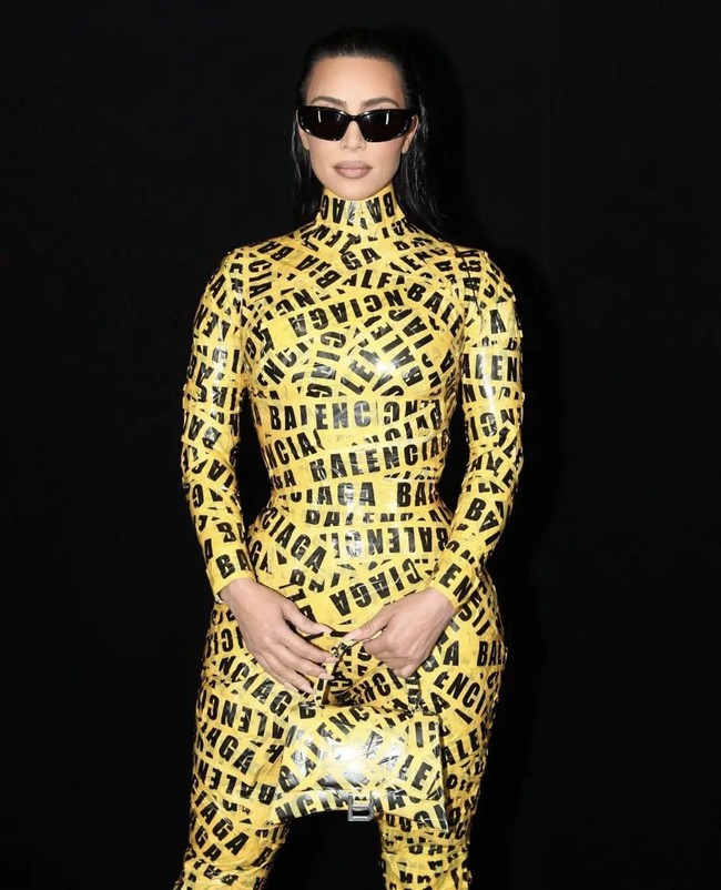 Penampilan Kim Kardashian kembali mencuri perhatian di Paris Fashion Week. Mantan istri Kanye West itu memakai manset hitam yang dilapisi lakban kuning bercetak logo Balenciaga, seperti tas dan sepatunya. Foto: Dok. AP