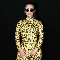 Penampilan Kim Kardashian kembali mencuri perhatian di Paris Fashion Week. Mantan istri Kanye West itu memakai manset hitam yang dilapisi lakban kuning bercetak logo Balenciaga, seperti tas dan sepatunya. Foto: Dok. AP