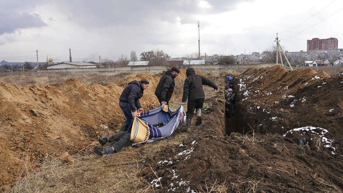Jenazah Korban Perang Ukraina vs Rusia Dikubur Massal Dead bodies are put into a mass grave on the outskirts of Mariupol, Ukraine, Wednesday, March 9, 2022 as people cannot bury their dead because of the heavy shelling by Russian forces. (AP Photo/Evgeniy Maloletka)